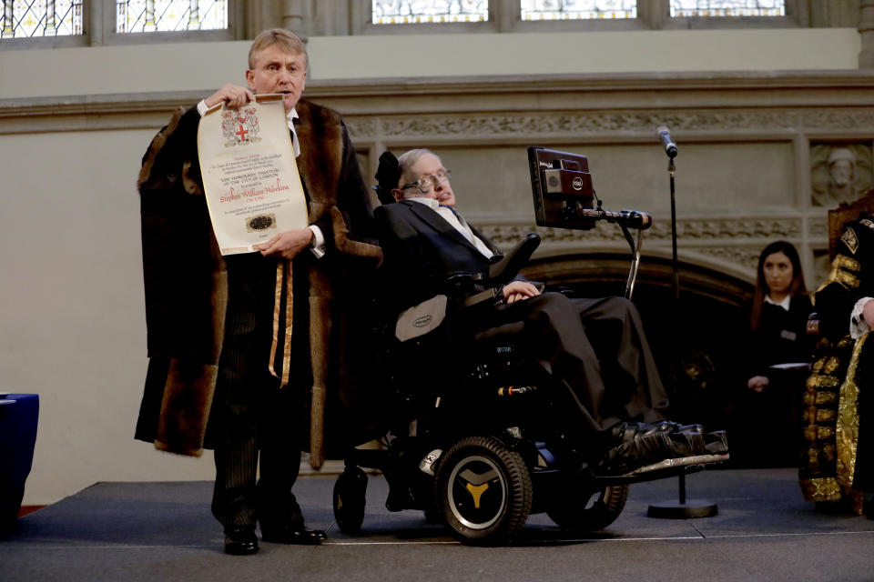 El profesor británico Stephen Hawking recibe su pergamino de la libertad iluminado por el chambelán de la ciudad de Londres, Peter Kane, mientras recibe la libertad honoraria de la ciudad de Londres durante una ceremonia en el Guildhall de la ciudad de Londres, el lunes 6 de marzo de 2017. Hawking recibió el premio más importante de la Corporación de la Ciudad de Londres el lunes en reconocimiento a su destacada contribución a la física teórica y la cosmología. (Foto AP/Matt Dunham)