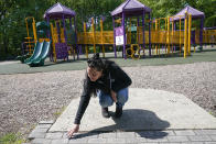 Erica Lafferty, whose mother Dawn Lafferty Hochsprung was killed during the Sandy Hook school shooting in 2012, points out some of the names of friends and family at the playground honoring her mother in Watertown, Conn., Wednesday, May 25, 2022. (AP Photo/Seth Wenig)