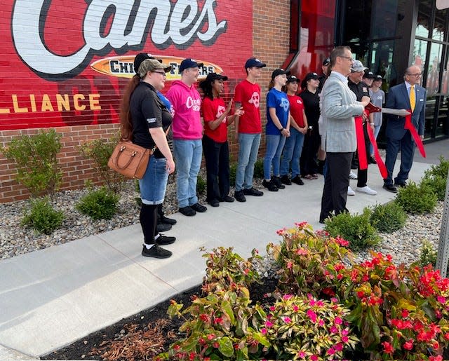 Alliance Mayor Andy Grove, far right, and Alliance Area Chamber of Commerce President Rick Baxter took part Tuesday in the grand opening event at Raising Cane's restaurant in Alliance.