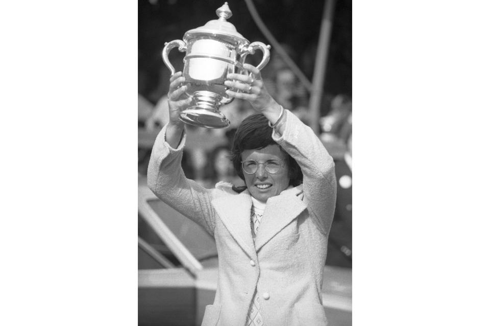 FILE - Billie Jean King holds up trophy she received in the Forest Hills neighborhood of the borough of Queens in New York, Sept. 9, 1972, for winning the women's title of the U.S. Open tennis tournament. King had just won the 1972 U.S. Open singles title when she demanded that the women's champion be paid the same as the men's winner the next year. That led the U.S. Open to become in 1973 the first sporting event to offer equal pay, and the 50th anniversary of that is being celebrated at this year's event. (AP Photo/John Rooney, File)