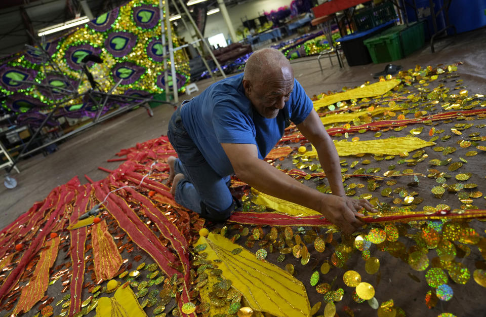 Kenney Coombs, a retired government employee, works on his latest design, titled Queens & Goddesses, at the Carnival Nationz's Mas Camp in Toronto, Canada, Sunday, July 24, 2022. The 55th annual parade returned to the streets after the COVID-19 pandemic cancelled it for two years in a row. (AP Photo/Kamran Jebreili)