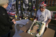 Royalty follower John Loughrey shows off a cake with a portrait of Princess Diana as he stands in front of the gates of Kensington Palace, in London, Wednesday, Aug. 31, 2022. Wednesday marks the 25th anniversary of Princess Diana's death in a Paris car crash. (AP Photo/Alastair Grant)