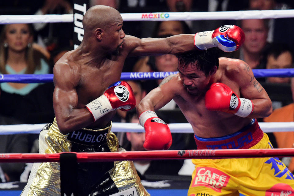 May 2, 2015; Las Vegas, NV, USA; Floyd Mayweather (black/gold trunks) and Manny Pacquiao (yellow/red trunks) box during their world welterweight championship bout at MGM Grand Garden Arena. Mayweather won via unanimous decsion. Mandatory Credit: Joe Camporeale-USA TODAY Sports