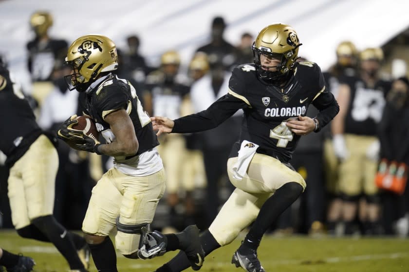 Colorado running back Jarek Broussard (23) takes the ball from quarterback Sam Noyer in the second half of an NCAA college football game Saturday, Nov. 28, 2020, in Boulder, Colo. Colorado won 20-10. (AP Photo/David Zalubowski)