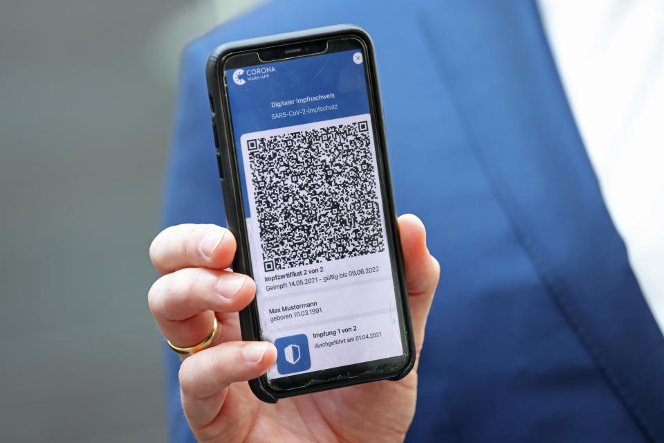 BERLIN, GERMANY - JUNE 10: German Health Minister Jens Spahn holds up a smartphone with the CovPass Covid vaccination digital certificate on a smartphone through Germany's Corona Warn app on June 10, 2021 in Berlin, Germany. CovPass will provide those who have been fully vaccinated against Covid-19 international certification. Countries across the EU have been working on a common platform for digital vaccination certification in particular to promote international summer travel and tourism. (Photo by Sean Gallup/Getty Images)