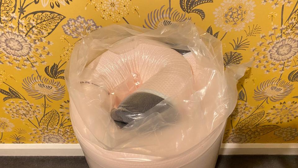 Image shows the Emma Original mattress tightly rolled and covered in tough plastic