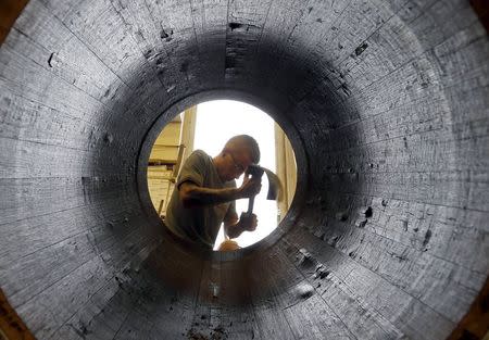 An employee works on an oak barrel in a workshop at the Hennessy factory in Cognac, southwestern France, November 5, 2015. REUTERS/Regis Duvignau