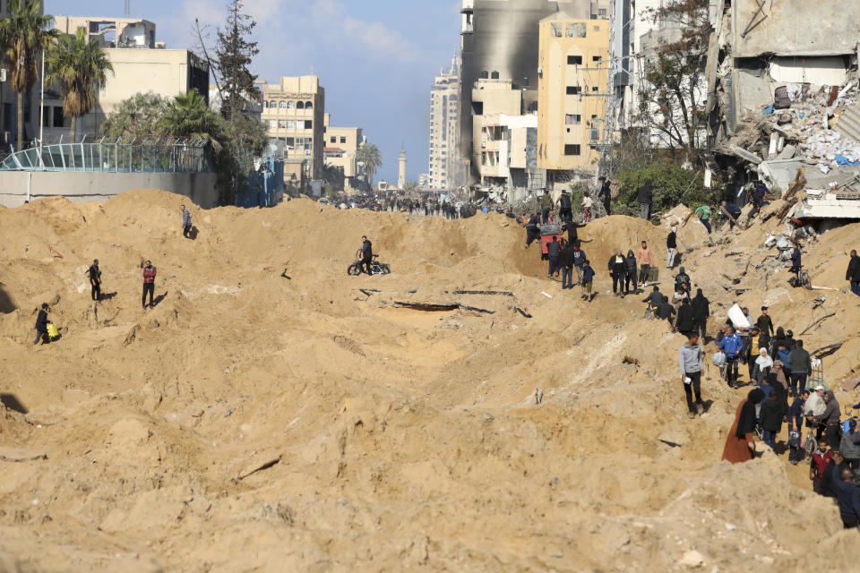 Palestinians walk through the destruction left by the Israeli air and ground offensive on the Gaza Strip in Gaza City, Saturday, Feb. 10, 2024. (AP Photo/Mohammed Hajjar)