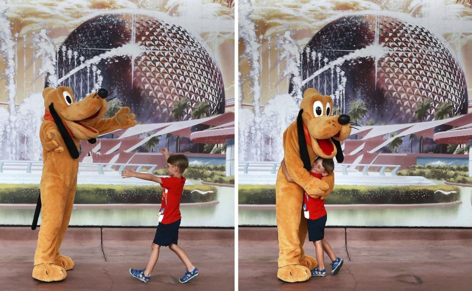 A young guest delights in getting a hug from Pluto at Walt Disney World in Florida on April 29, 2022.