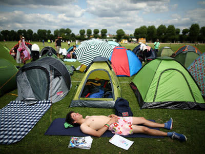 <p>A tennis fan relaxes in the sun outside his tent during day two of the Wimbledon Lawn Tennis Championships at the All England Lawn Tennis and Croquet Club on June 25, 2013 in London, England.</p>