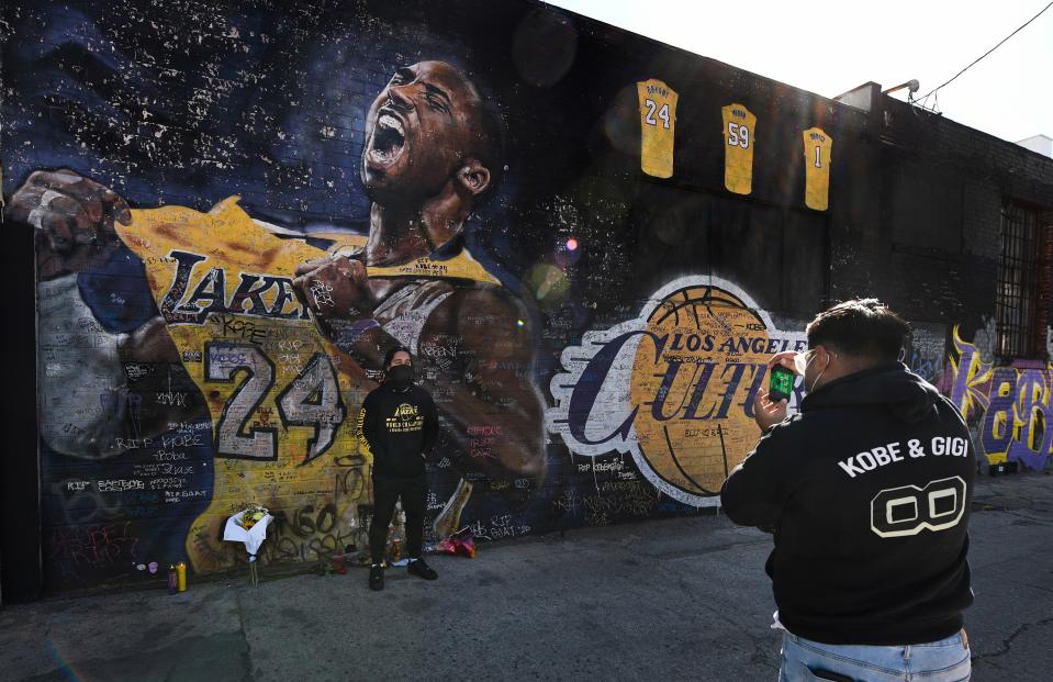Fans take snapshots in front of a mural of Kobe Bryant in downtown Los Angeles.