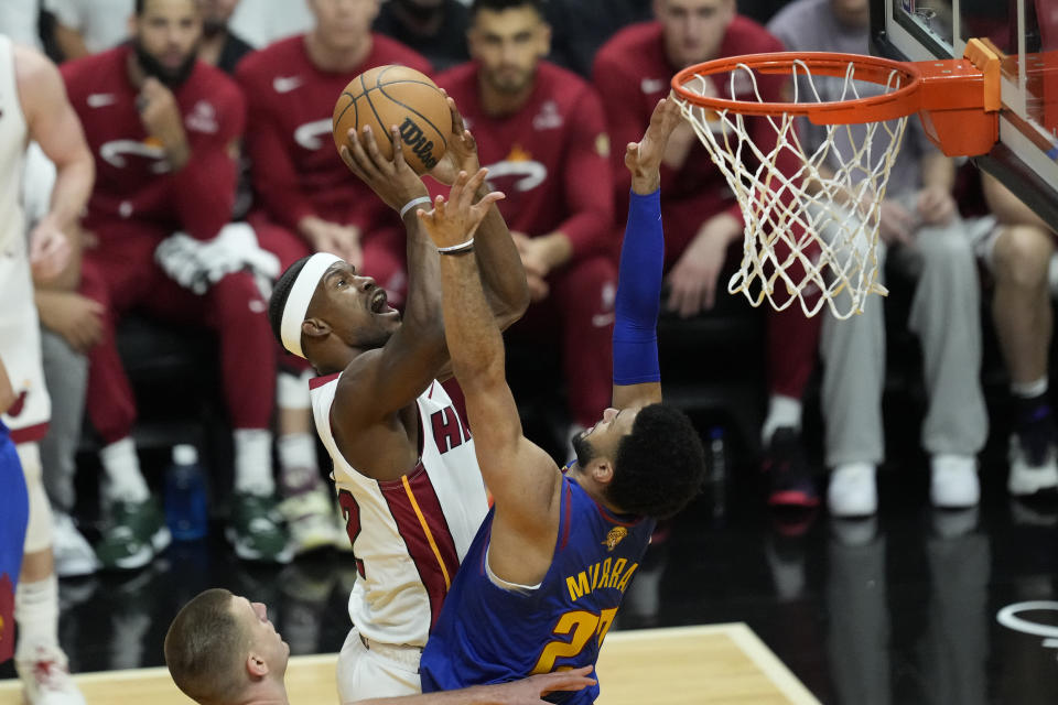 Miami Heat forward Jimmy Butler (22) drives to the basket as Denver Nuggets guard Jamal Murray (27) defends during the first half of Game 3 of the NBA Finals basketball game, Wednesday, June 7, 2023, in Miami. (AP Photo/Rebecca Blackwell)