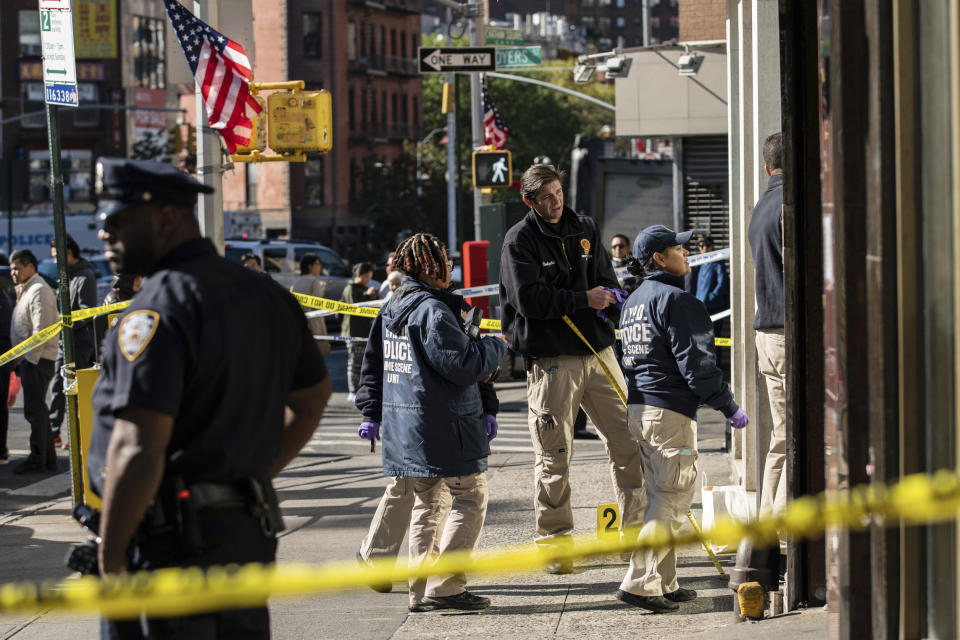 New York Police Department officers investigate the scene of an attack in Manhattan's Chinatown neighborhood, Saturday, Oct. 5, 2019 in New York. Four men who are believed to be homeless were attacked and killed early Saturday in a street rampage. NYPD Detective Annette Shelton said that a fifth man remained in critical condition after also being struck with a long metal object that authorities recovered. (AP Photo/Jeenah Moon)