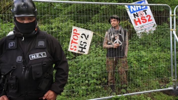 Una patrulla de seguridad del Equipo Nacional de Desalojo fuera del bosque cercado de un campamento de protesta en Bluebell Wood en Staffordshire en mayo de 2022