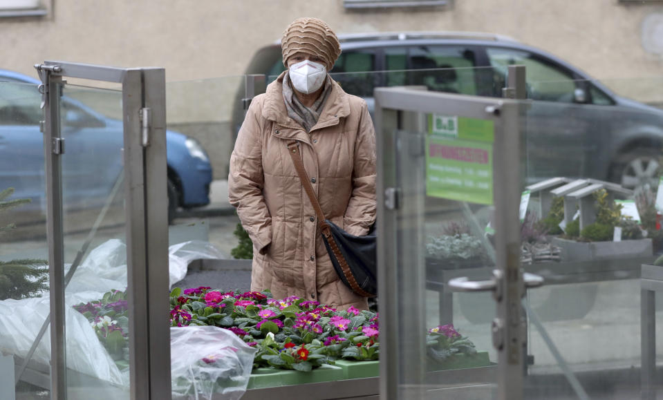 A woman with masks shops in a reopened store after lock down in Vienna, Austria, Monday, Feb. 8, 2021. The Austrian government has moved to restrict freedom of movement for people, in an effort to slow the onset of the COVID-19 coronavirus. (AP Photo/Ronald Zak)