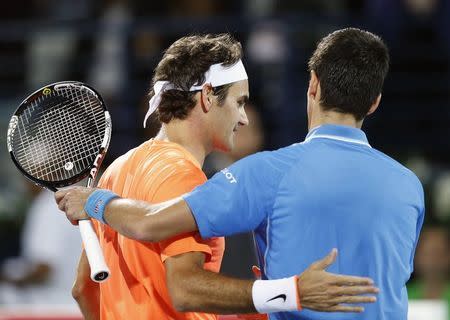 Roger Federer of Switzerland (L) shakes hand with Novak Djokovic of Serbia after their final match at the ATP Championships tennis tournament in Dubai February 28, 2015. REUTERS/Ahmed Jadallah