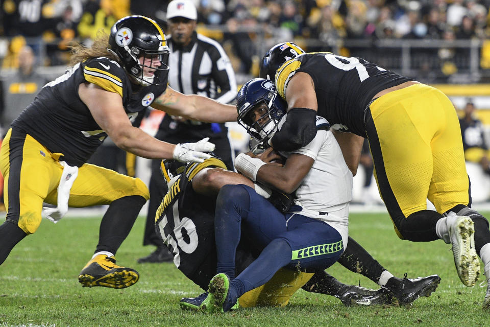 Seattle Seahawks quarterback Geno Smith (7) is sacked by Pittsburgh Steelers outside linebacker Alex Highsmith (56), defensive end Henry Mondeaux (99), left, and defensive end Chris Wormley (95), right, during the second half an NFL football game, Sunday, Oct. 17, 2021, in Pittsburgh. (AP Photo/Don Wright)