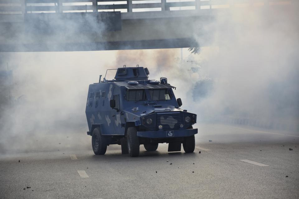 An armored personnel carries drives back after firing tear gas shell to disperse supporters of former Pakistani Prime Minister Imran Khan's party, 'Pakistan Tehreek-e-Insaf' during a protest to condemn a shooting incident on their leader's convoy, in Rawalpindi, Pakistan, Friday, Nov. 4, 2022. Khan who narrowly escaped an assassination attempt on his life the previous day when a gunman fired multiple shots and wounded him in the leg during a protest rally is listed in stable condition after undergoing surgery at a hospital, a senior leader from his party said Friday. (AP Photo/W.K. Yousafzai)