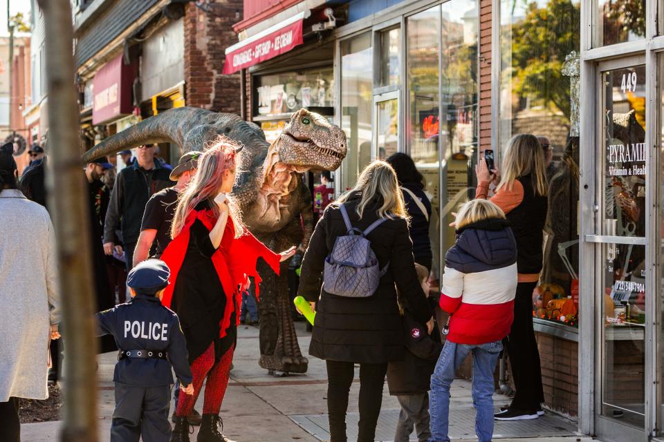 A T-Rex walks along Main Street as part of the Halloween festivities.