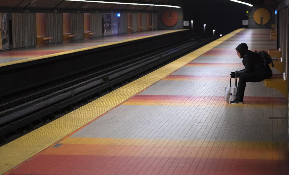 A commuter wearing a protective mask waits in an empty subway station in Montreal, on Wednesday, April 22, 2020. Proper physical distancing in public transportation is a concern as governments prepare to start easing restrictions. (Paul Chiasson/The Canadian Press via AP)