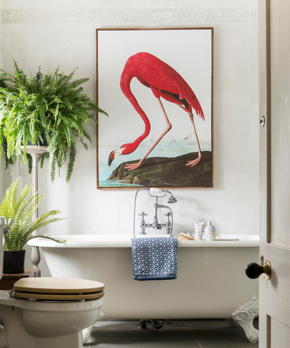 traditional bathroom with roll-top bath with flamingo wall art  and fern plants