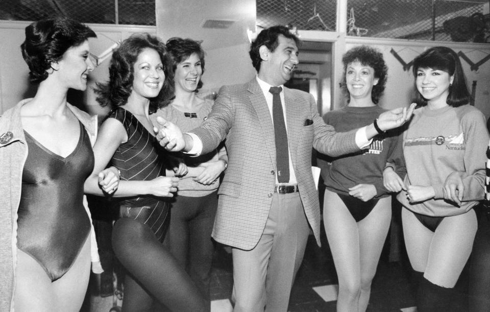 FILE - In this Feb. 27, 1984, file photo, singer Placido Domingo laughs with members of the Rockettes at New York's Radio City Music Hall. The singer and dancers met while rehearsing for Channel Thirteen's "Gala of Stars 1984." Nine women in the opera world have told The Associated Press that they were sexually harassed by Domingo, one of the most celebrated and powerful men in opera. The women say the encounters took place over three decades, at venues that included opera companies where he held top managerial positions. (AP Photo/Steve Friedman, File)