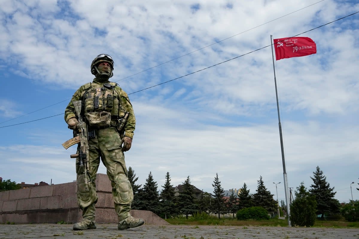 A Russian soldier stands guard in the Moscow-controlled city of Kherson, south Ukraine on 20 May, 2022 (AP)