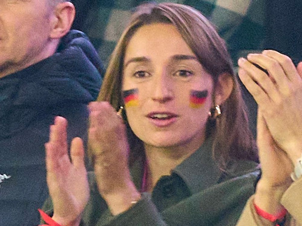 Lena Wurzenberger mit Deutschlandfahne im Gesicht und dem pinken Trikot unter ihrer Jacke beim Spiel gegen die Niederlande. (Bild: IMAGO/ActionPictures)