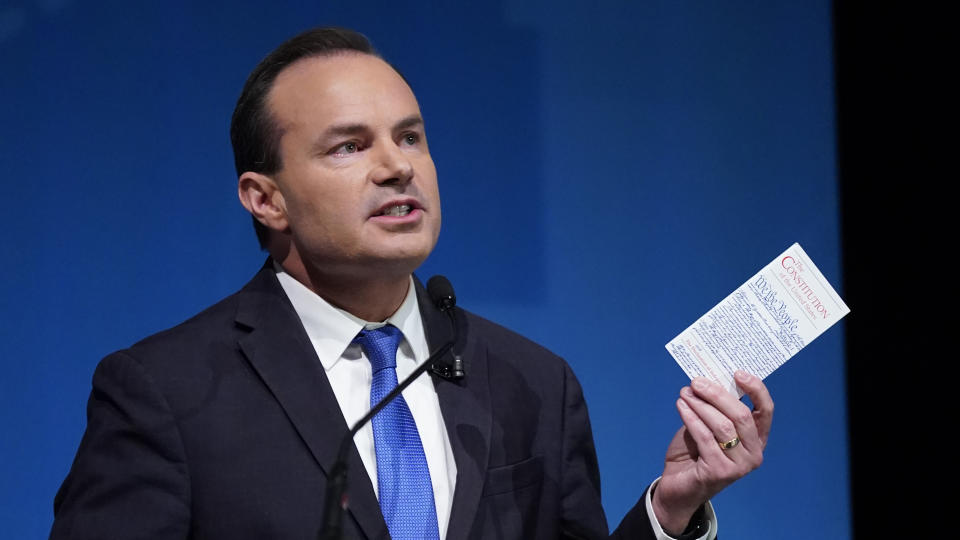 FILE - Utah Republican Sen. Mike Lee holds his pocket Constitution of the United States during a televised debate with his independent challenger Evan McMullin on Oct. 17, 2022, in Orem, Utah. Tech companies and Democratic Party-aligned groups are among those funneling millions into Utah to support McMullin's bid to unseat Lee. (AP Photo/Rick Bowmer)