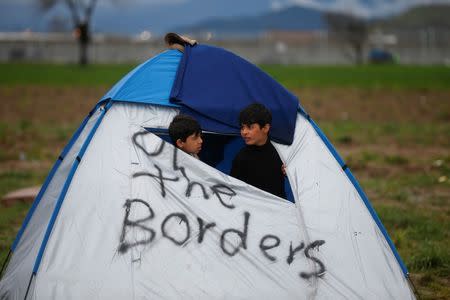 Migrant children stand in a tent at a makeshift camp on the Greek-Macedonian border near the village of Idomeni, Greece March 10, 2016. REUTERS/Stoyan Nenov