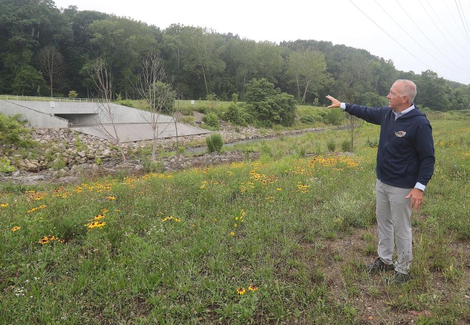 Akron Mayor Dan Horrigan stands near the Ohio Canal Interceptor Tunnel and points to the proposed site of a $209 million facility mandated by a 2004 consent decree.