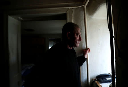 Laszlo Reisch, 48, looks out a window at home in Hosszuheteny, Hungary, March 26, 2018. Picture taken March 26, 2018. REUTERS/Bernadett Szabo