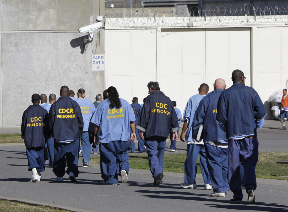 FILE - In this Feb. 26, 2013, file photo, inmates walk through the exercise yard at California State Prison Sacramento, near Folsom, Calif. The California Labor and Workforce Development Agency confirmed Tuesday, Dec. 1, 2020, that California has sent about $400 million in unemployment benefits to state prison inmates. In all records show 31,000 inmates have applied for benefits and about 20,800 were paid $400 million. A group of local and federal prosecutors said 133 inmates on death row were named in claims. (AP Photo/Rich Pedroncelli, File)