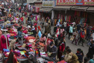 FILE - A police man, center, directs pedestrians towards a COVID-19 testing booth at a Sunday market in Jammu, India on Dec.5, 2021. In India, which has been getting back to normal after a devastating COVID-19 outbreak earlier this year, omicron is once again raising fears, with more than 700 cases reported in the country of nearly 1.4 billion people. (AP Photo/Channi Anand, File)
