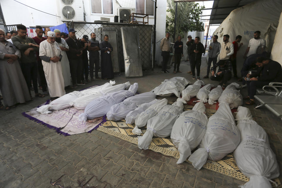 Palestinians pray by the bodies of the Hijazi family that was killed in the Israeli bombardment of the Gaza Strip in Rafah on Friday, Nov. 10, 2023. (AP Photo/Hatem Ali)