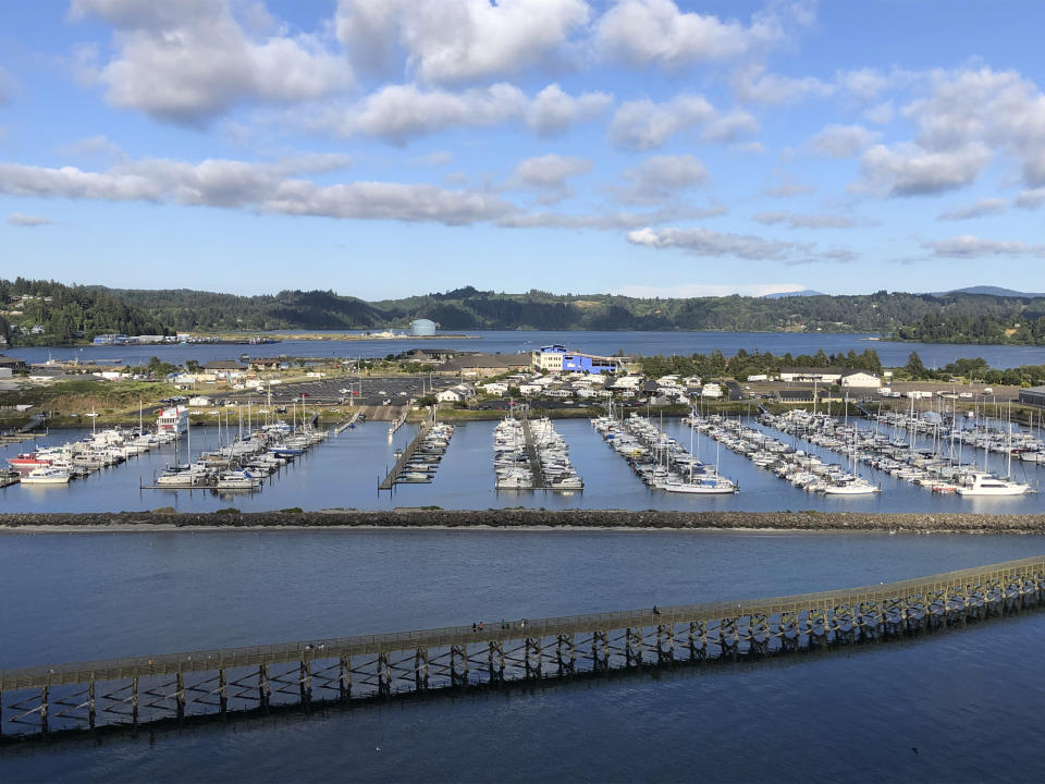 In this July 22, 2019, photo, Oregon State University's Marine Studies Building, which is under construction in a tsunami inundation zone, is seen from the Yaquina Bay Bridge in Newport, Ore. The building, slightly right of center in the middle of the photograph, is surrounded by Yaquina Bay. Construction workers in this Oregon coastal town are erecting the building right in the path of a future tsunami that experts say will be generated by a huge offshore earthquake that is certain to occur sooner or later. (AP Photo/Andrew Selsky)