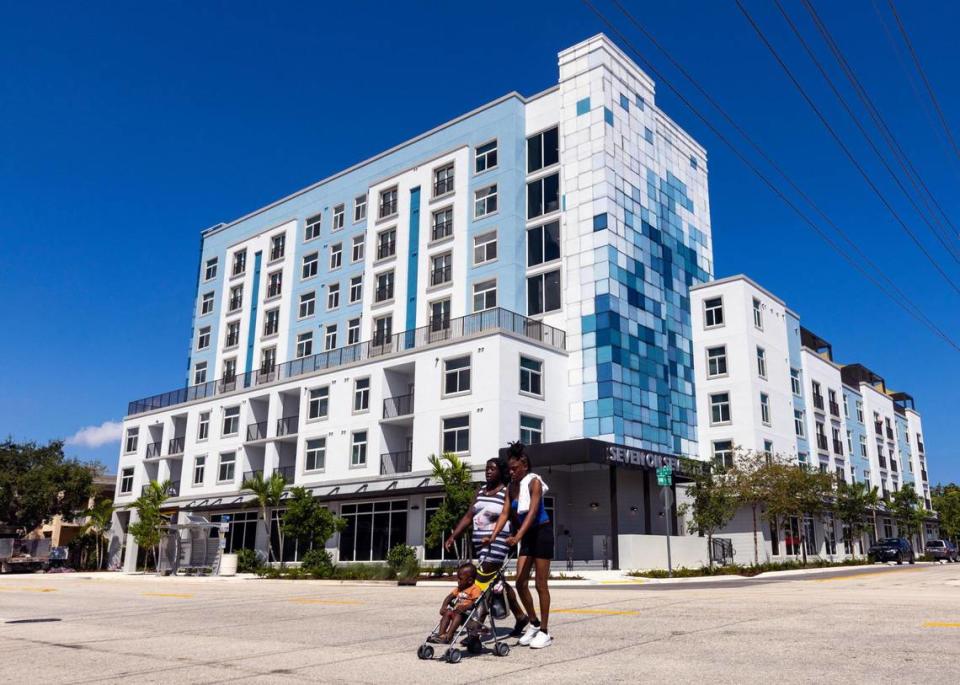 Two women and a baby cross the street in front of the new affordable housing complex Seven on Seventh in Fort Lauderdale, Florida, on Wednesday, September 13, 2023.