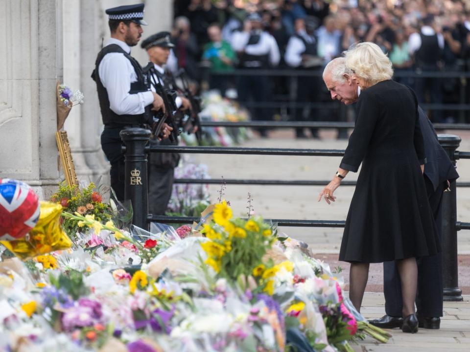 King Charles III and Queen Consort Camilla look at flowers at Buckingham Palace on Setpember 9, 2022.