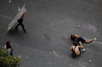 Demonstrators lay on the ground as they react to the sound of gunfire during clashes with security forces following a rally against the government of Venezuela's President Nicolas Maduro and to commemorate May Day in Caracas Venezuela, May 1, 2019. REUTERS/Adriana Loureiro