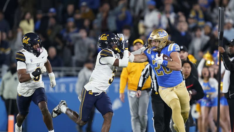 UCLA’s Carsen Ryan, right, stiff-arms California defensive back Nohl Williams as defensive back Patrick McMorris gives chase during game Saturday, Nov. 25, 2023, in Pasadena, Calif. On Thursday, the American Fork product announced he is transferring to Utah.