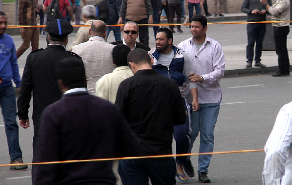 In this image taken from AP Television, Egyptian security forces arrest a man after multiple explosions hit the area outside the main campus of Cairo University, killing at least two, in Giza, Egypt, Wednesday, April 2, 2014. The bombings targeted riot police routinely deployed at the location in anticipation of near-daily protests by students who support ousted Islamist President Mohammed Morsi and his Muslim Brotherhood group. (AP Photo/AP Video)