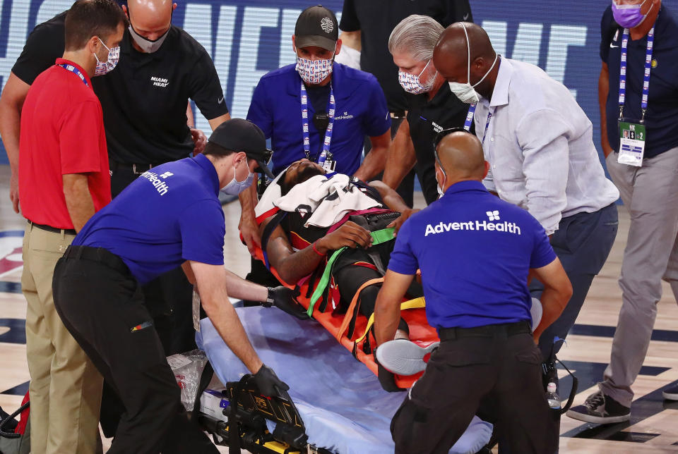 Miami Heat forward Derrick Jones Jr. (5) is tended to by medical personnel after colliding with Indiana Pacers center Goga Bitadze (not pictured) during the second half of an NBA basketball game Friday, Aug. 14, 2020, in Lake Buena Vista, Fla. (Kim Klement/Pool Photo via AP)