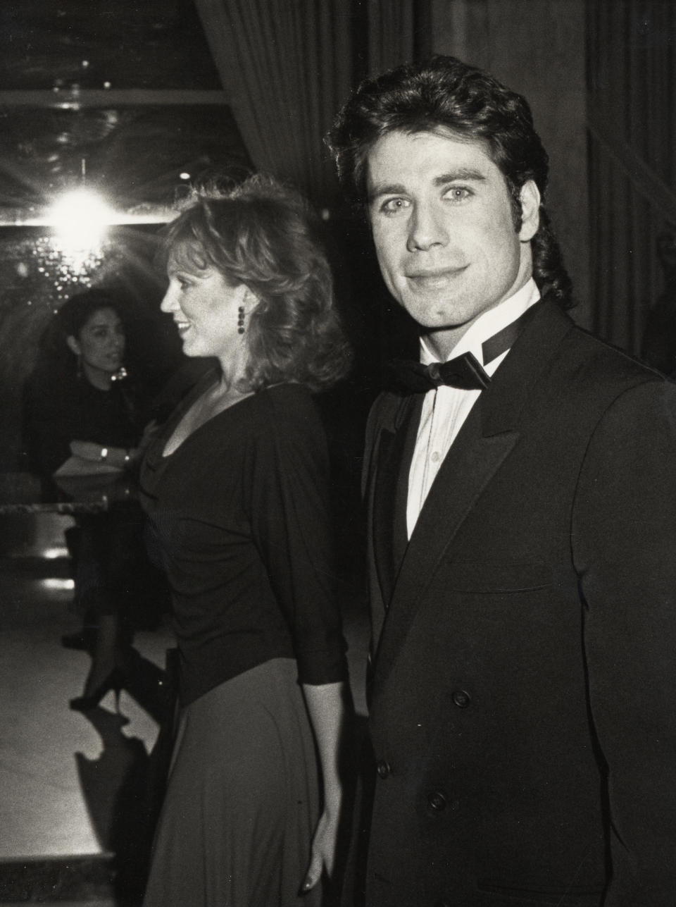 John Travolta in a tuxedo and an unidentified woman in a black dress at a formal event