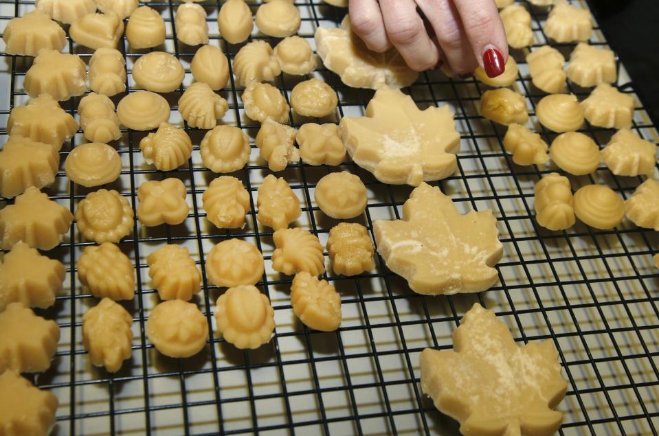 In this March 14, 2014 photo, Kathy Gallagher places maple sugar candy on a drying rack at the Turtle Lane Maple sugar house in North Andover, Mass. Maple syrup season is finally under way in Massachusetts after getting off to a slow start because of unusually cold weather. (AP Photo/Elise Amendola)