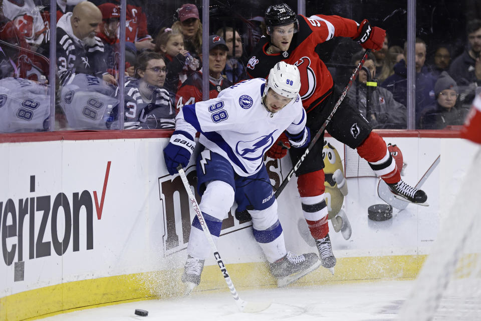 Tampa Bay Lightning defenseman Mikhail Sergachev (98) and New Jersey Devils center Dawson Mercer battle for the puck during the second period of an NHL hockey game Tuesday, March 14, 2023, in Newark, N.J. (AP Photo/Adam Hunger)