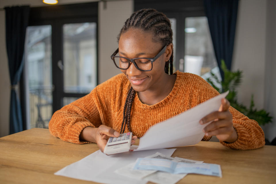 Woman planning home budget and using calculator