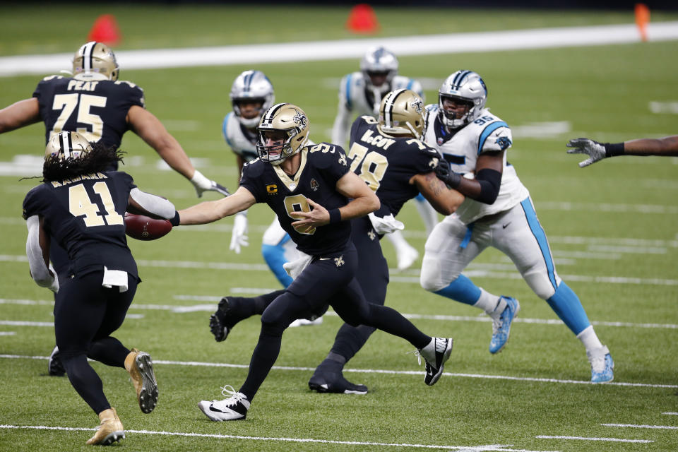 New Orleans Saints quarterback Drew Brees (9) hands off to running back Alvin Kamara (41) in the first half of an NFL football game against the Carolina Panthers in New Orleans, Sunday, Oct. 25, 2020. (AP Photo/Brett Duke)