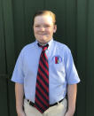 This Aug. 5, 2020 photo released by Courtney Pulitzer shows her son Simon Joubeaud Pulitzer, 10, in Tucson, Ariz. Simon returned to his private school on Aug. 3, his blue button-down uniform shirt and tie in place. He was happy to see his friends again and have face-to-face access to his teachers. (Courtney Pulitzer via AP)