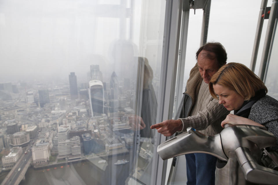 People look at London's skyline from the viewing platform of a skyscraper in central London, Thursday, April 3, 2014. British authorities have warned people with heart or lung conditions to avoid exertion as a combination of industrial pollution and Sahara dust blankets the country in smog. The environment department said air pollution level could reach the top rung on its 10-point scale. The pollution is expected to ease by Friday. (AP Photo/Lefteris Pitarakis)