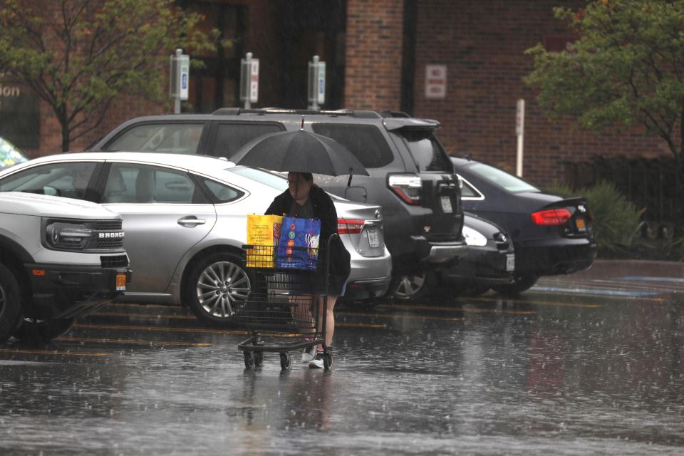 A shopper at Wegmans in Canandaigua, New York, walks to her vehicle in the rain on Friday, Aug. 9, 2024. Heavy rainfall and flooding from the remnants of Debby affected the Northeast.